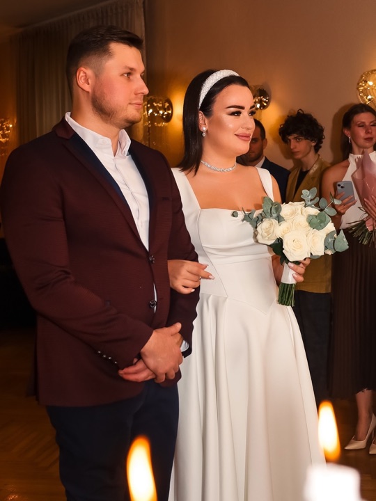 A wedding couple at a ceremony with candles in the foreground