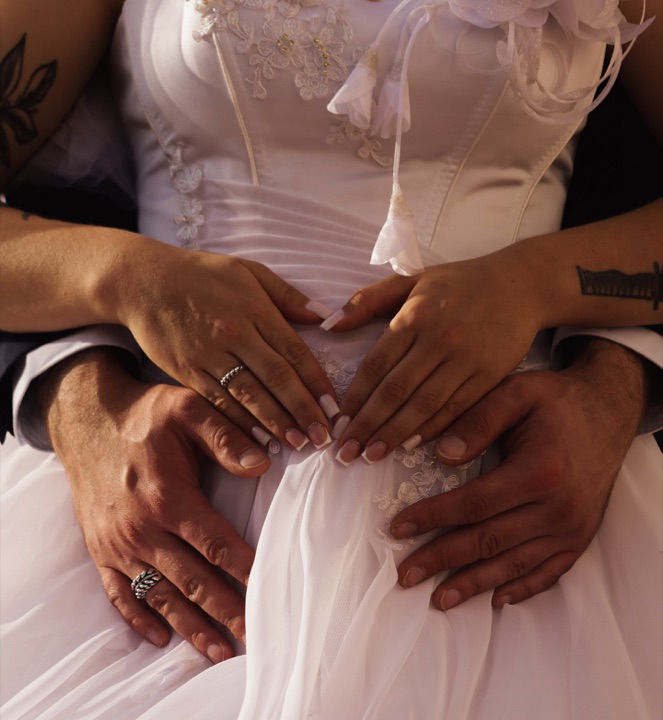 A close view of hands on a wedding dress